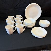Full set display including 8 mugs, 8 bowls, 8 salad plates, and 1 large serving bowl on a black background