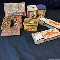 Overall view of the collection showing multiple decorative tins, matchboxes and matches with colorful heads.
