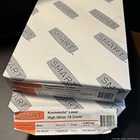 Photo showing one sealed bundle of Kromekote Laser High Gloss 1S Cover paper with label details