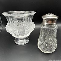 Side view of Lalique frosted glass bowl with floral motif and pedestal base next to cut crystal shaker with silver top
