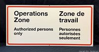 Photo of the front of the aluminum sign showing bilingual operations zone warning text.