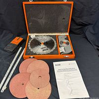 Photo showing entire contents of the wood case including dado saw blades, sanding discs, hacksaw blades, stud finder and instructions.
