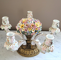 Front view of entire five-arm candelabra showing porcelain arms, floral center and metal base