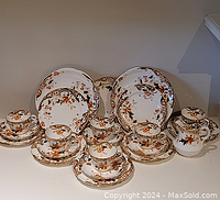Full view of the Aynsley Imari dessert set including plates, cups, saucers, and a creamer showing the overall design and condition.