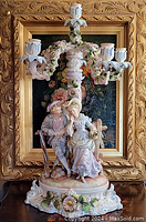 Overall front view of porcelain candelabra with figural couple and floral arms