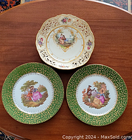 Three-piece set: two decorative plates and one bowl, all with romantic 18th-century style illustrations and ornate detailing.