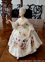 Front view of the Royal Doulton Diana figurine showing detailed floral patterns on the dress and the figure holding a red item.