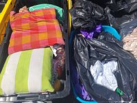 Bins filled with assorted pillows showing a variety of colors and patterns including red and orange checkered, green strip, and floral designs.