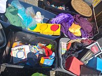 Bins filled with various items including colorful fabrics, household items, and part of a yellow-framed object visible.