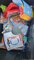Overview of bin showing children's books and various toys packed inside.