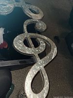 Metal treble clef musical symbol sign with galvanized metal finish, rustic and industrial style.