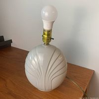 White ceramic round table lamp base with grooved pattern and brass lamp socket without shade