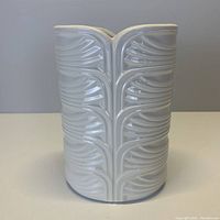 Front view of white ceramic vase with leaf pattern
