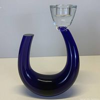 Front view of solid cobalt blue glass candle holder with integrated clear glass candle cup on top, no visible chips or cracks.