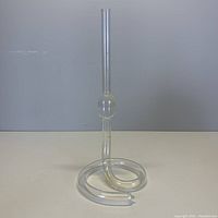 Front view of the clear glass bud flower vase with curved, coiled base on a plain background.