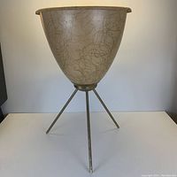 Full front view of the mid century atomic planter on tripod metal legs showing overall design.