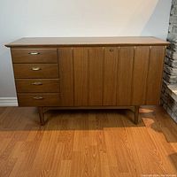 Front view of the cedar chest showing four drawers on the left and vertical panel design on the right cabinet door.