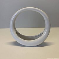 Front view of small white circular ceramic planter shown against plain background