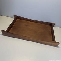 View of wooden tray from above showing the interior surface and raised edges.