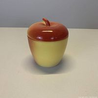 Front view of vintage apple-shaped ceramic jar with a stem lid