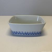 Front angle photo of white ceramic rectangular dish with blue floral pattern around bottom sides.
