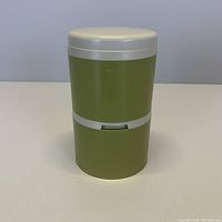 Front view of vintage avocado green Rubbermaid shaker with white lid and stackable design