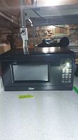 Front view of black Master Chef microwave showing keypad, display, and door with window.