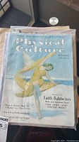 Photo showing Physical Culture magazine February issue 25c cover with woman posed in flowing fabric, visible wear on spine and edges