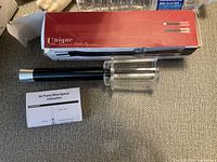 Photo showing the air pump wine opener, instruction manual and original box with red and black design.