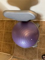 Top view of the balance ball chair showing the purple exercise ball and gray backrest against a tiled floor.