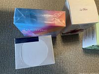 Four boxed cosmetic products viewed from above and sides, showing packaging and brands