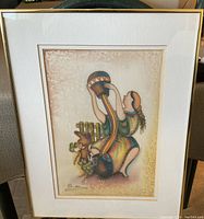Framed signed painting with a figure holding a decorated pot, mounted under glass in a gold frame.