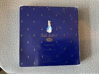 Top view of the original Wedgwood box showing dark blue color with small gold bunny motifs, Peter Rabbit logo and 2000 year mark.