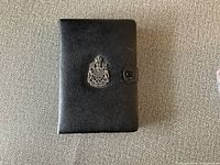 Black leather case with silver crest emblem, closed view