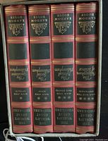 Photo of four vintage hardcover philosophy books in red and green with gold and black detailing on spine.