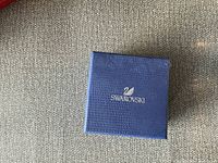 Closed blue Swarovski box with logo embossed on top, providing packaging detail.