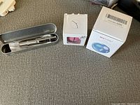 Multiple cat toys including a Glide'n air-gliding toy in box, a metallic laser pointer in metal case, a small cat toy in paw-print packaging, and a Bentioral light projector toy in box.