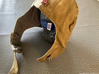 Side angle photo showing the tan canvas pilot helmet with inner lining and red Soviet star badge attached on front.