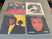 Four vinyl records on a table: Rod Stewart 'Tonight I'm Yours', Diana Ross, Phil Collins 'No Jacket Required', and one other album.