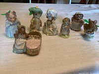 Seven assorted Beswick Beatrix Potter ceramic figurines arranged on a flat surface, showing the full group and their detailed appearances.