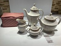 Set of Royal Doulton White Nile china including coffee pot, teapot, creamer, covered sugar bowl, and padded protective fabric case