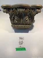 Front view of the ornate molded shelf showing detailed leaf carvings and decorative molding.