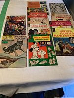 Overview photo showing all 12 vintage comic books laid out on a white surface with a green accent.