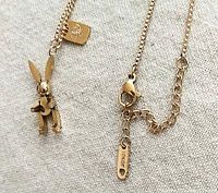 Photo of gold-plated rabbit charm on chain with jeweler's tag showing charm detail and chain texture.