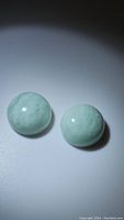 Photo of two round cabochon amazonite gemstones showing the front surface with robin egg blue color and natural grain patterns.
