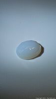 Top view of oval faceted lavender pearl chalcedony gemstone showing translucent light lavender color.