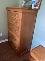 Side view of highboy dresser showing solid wood construction and metal drawer handles.