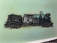 Side view of the entire model locomotive including the tender labeled "Stillwater Timber Company."