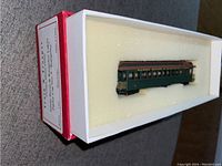 Train car viewed inside foam padding-lined white box with red edge, showing original packaging and label