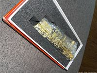 Brass locomotive wrapped in protective plastic inside foam-lined box